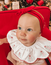 Baby girl is wearing a comfortable knot headband for little girls from By Bella Boutique.